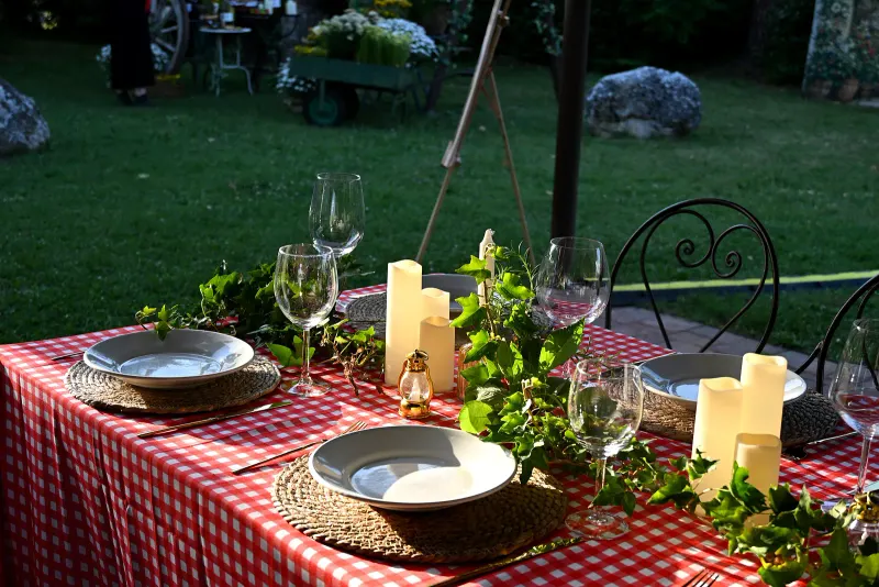 Aufbau einer Hochzeitsfeier im Borgo Santa Maria — Gedecke, Kerzen und Efeu: das Detail der Tafel