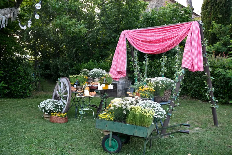 Aufbau einer Hochzeitsfeier im Borgo Santa Maria — Stoffbahnen und Karren voller weißer Blumen am Eingang