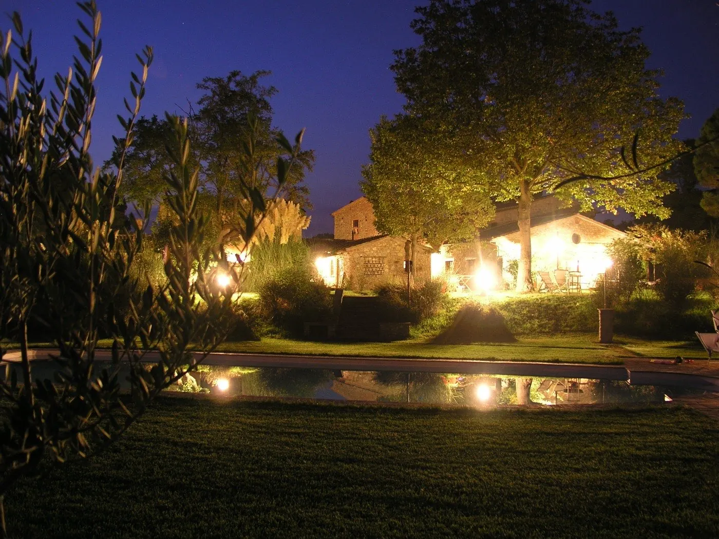 Pool bei Nacht mit beleuchteten Häusern